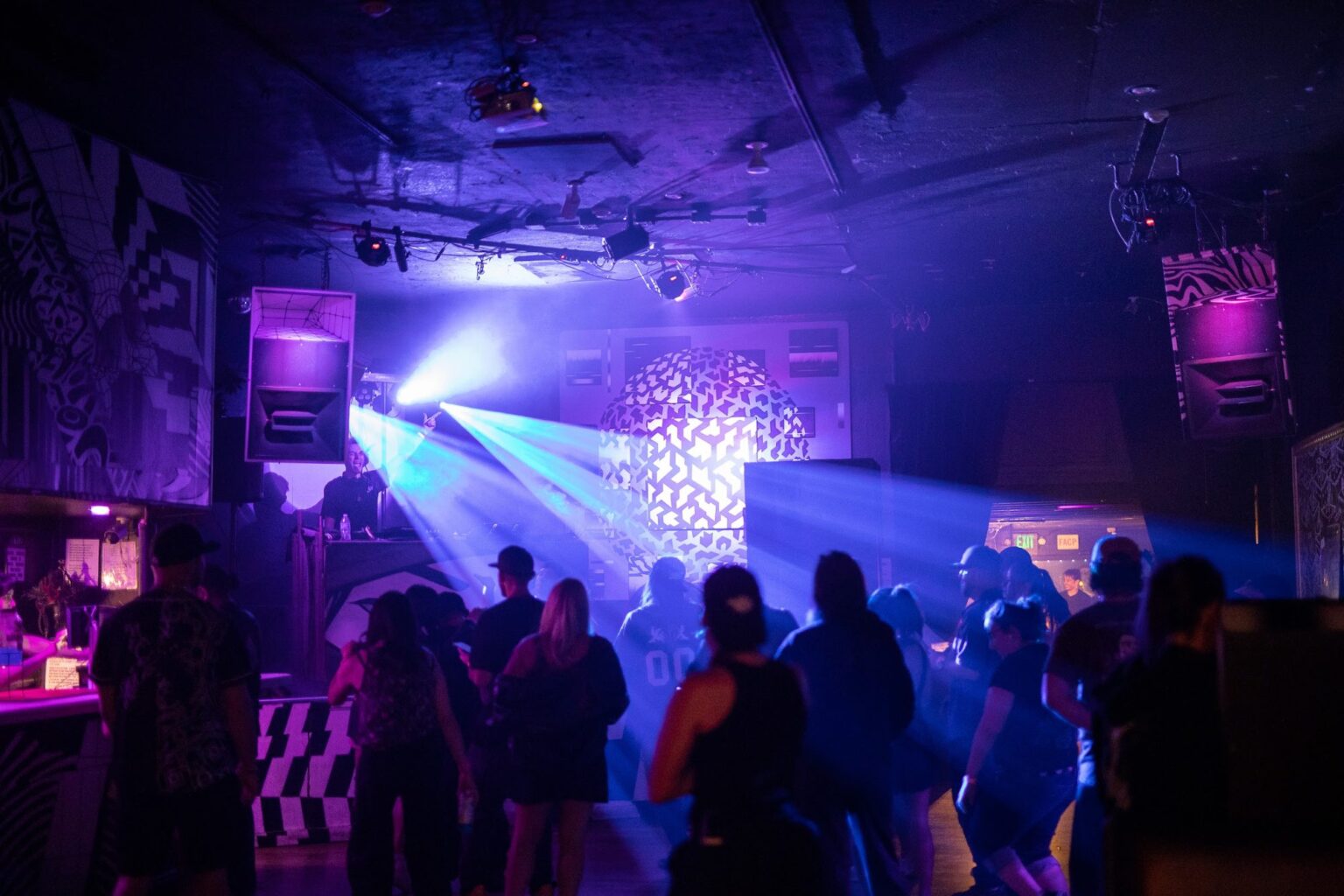 Dance floor under blue beams and haze at PULSE
